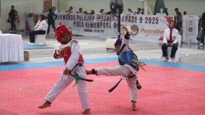 Dua atlet cilik saling adu teknik dalam pertandingan Liga Taekwondo Pelajar Indonesia 2025 di GOR Indoor Kelapa Dua, Tangerang.