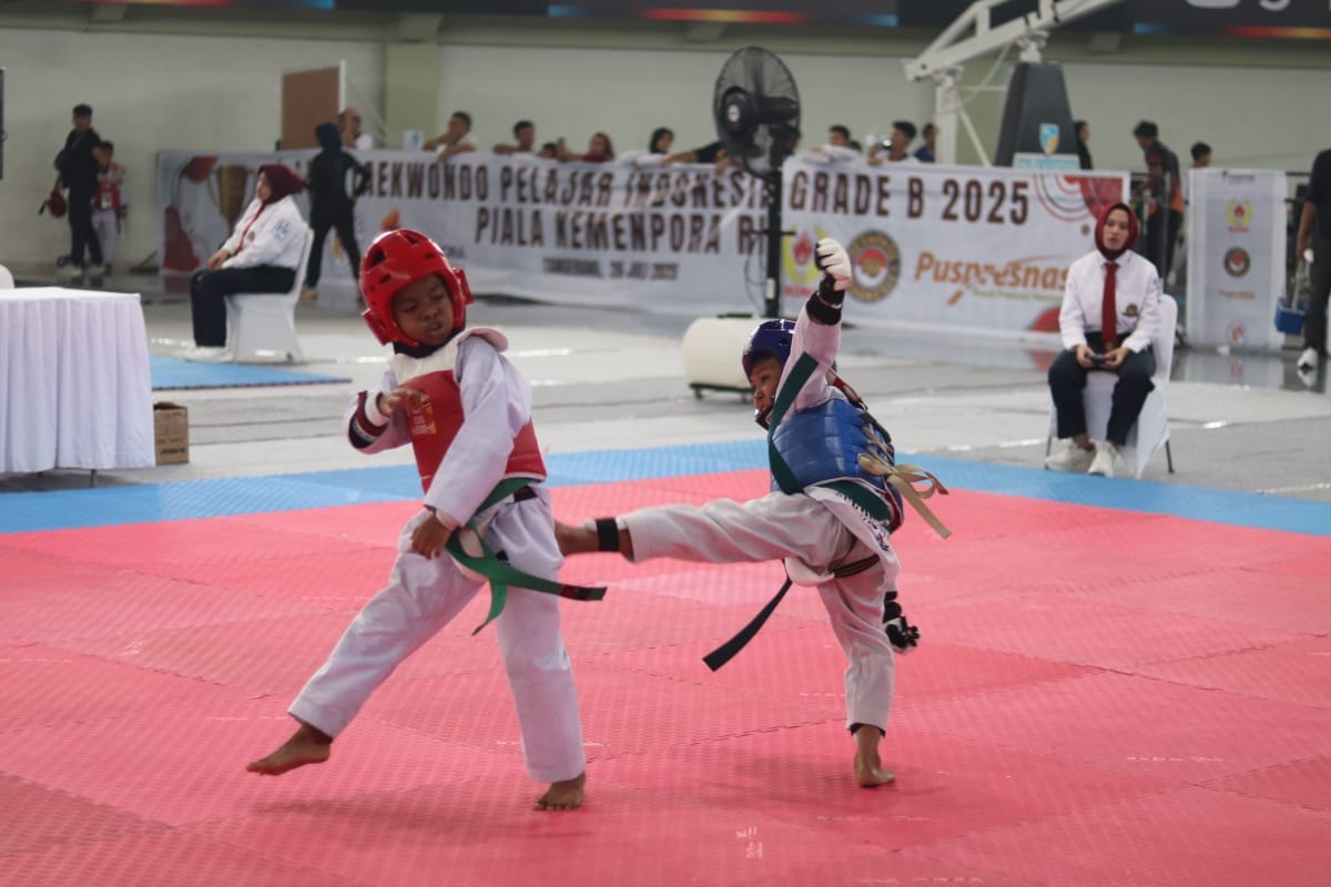 Dua atlet cilik saling adu teknik dalam pertandingan Liga Taekwondo Pelajar Indonesia 2025 di GOR Indoor Kelapa Dua, Tangerang.